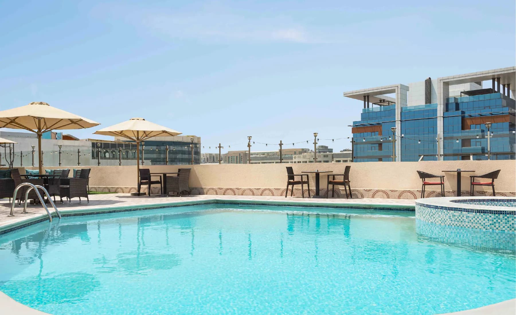 The rooftop swimming pool with loungers and umbrellas
